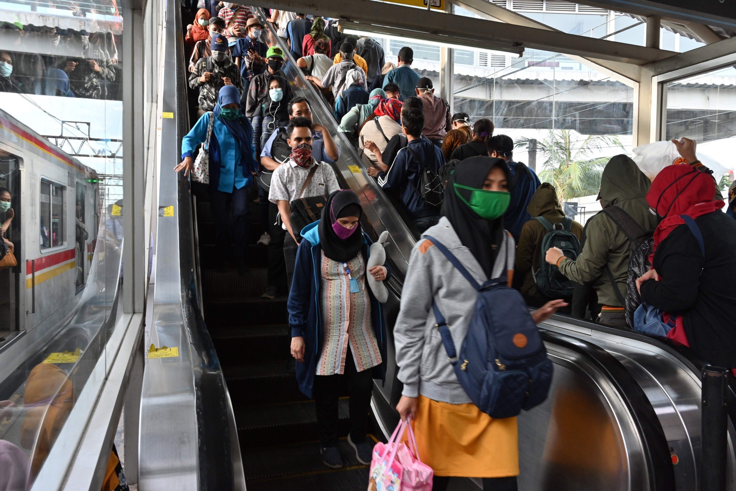 People wearing face masks, amid the coronavirus outbreak, commute at Tanah Abang train station, Jakarta on April 7, 2020 (Photo by ADEK BERRY/AFP via Getty Images)