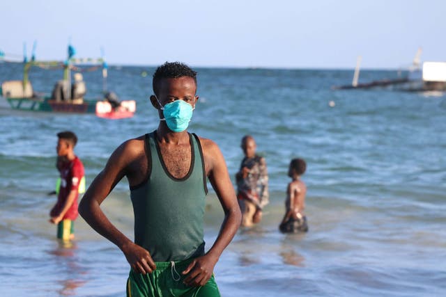 A man wears a mask as a protective measure to curb the Covid-19 coronavirus while bathing at Lido beach in Mogadishu, Somalia