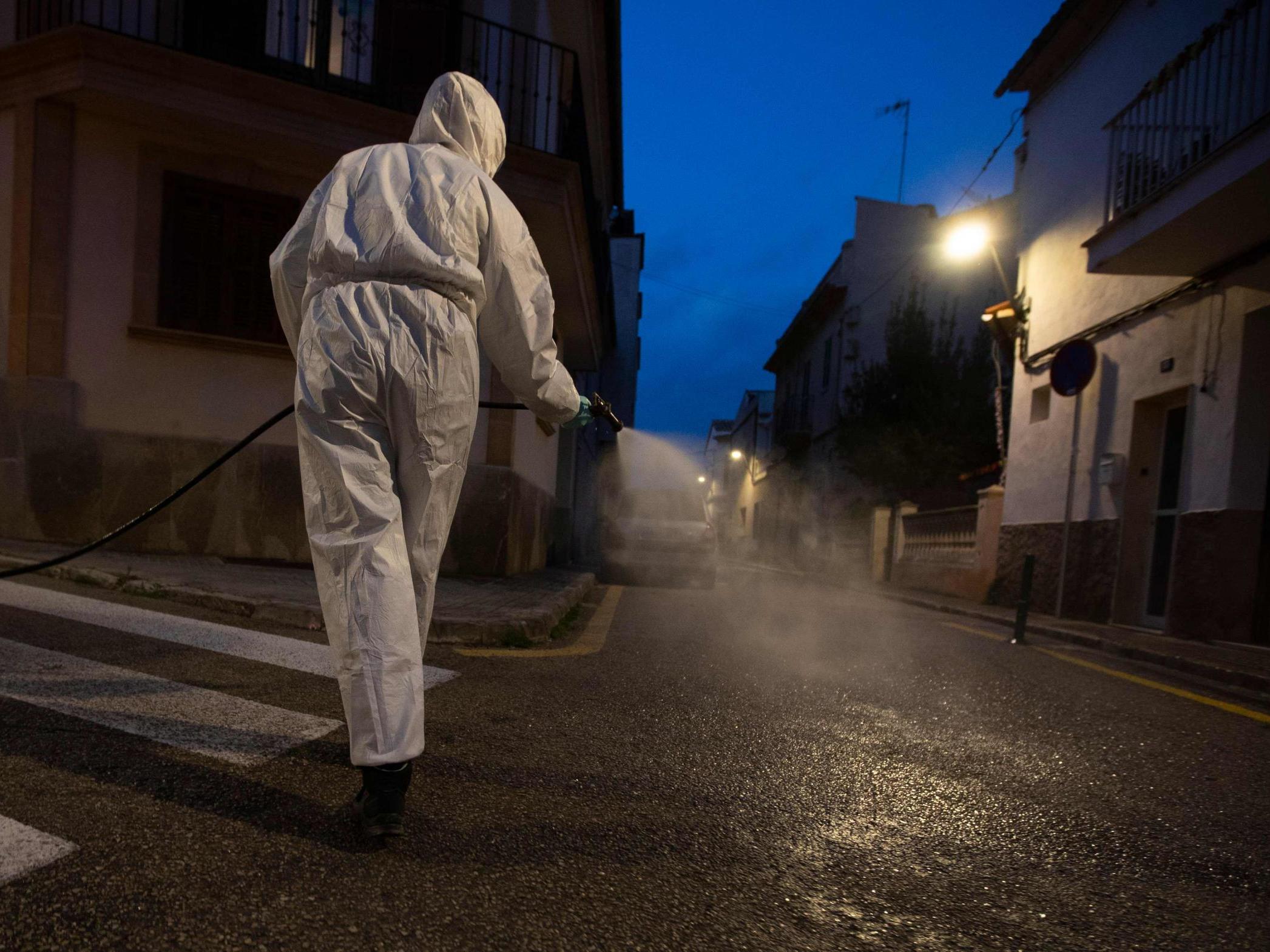 A volunteer farmer caries out a disinfection in the town of Sant Jordi, on the Balearic island of Mallorca on 10 April, during a national lockdown to prevent the spread of the COVID-19 disease