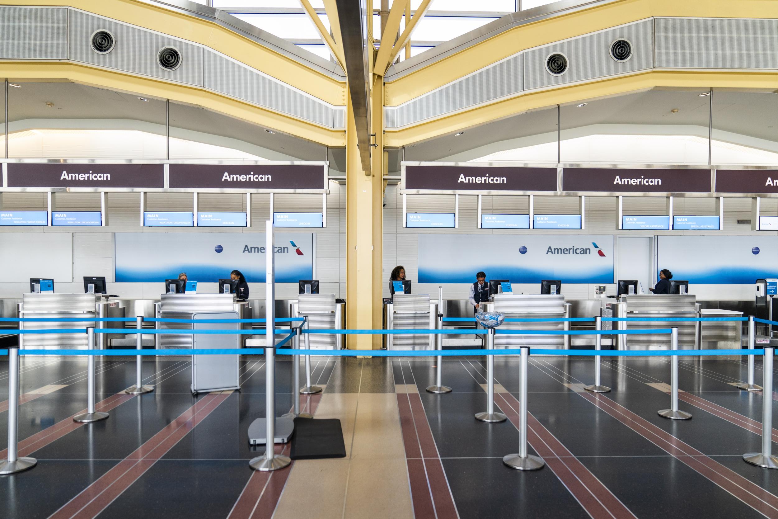 American Airlines agents wait for customers in a near empty Ronald Reagan Washington National Airport