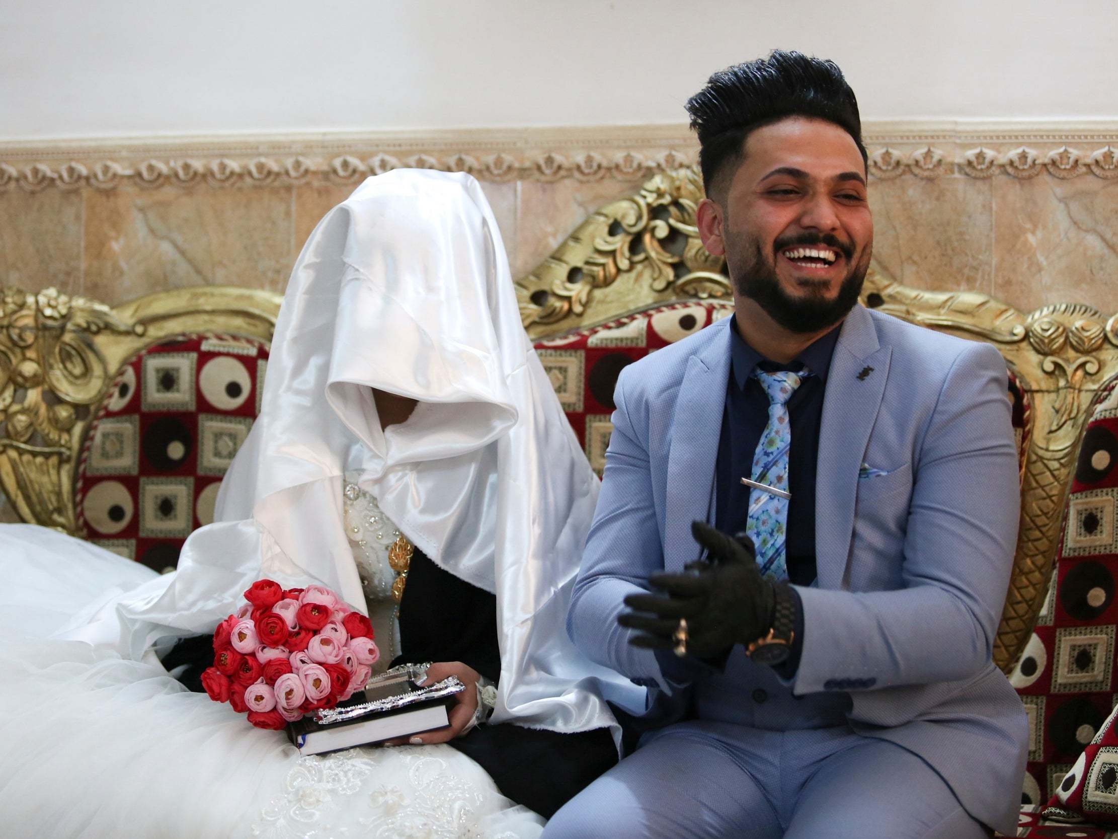 Ahmed Khaled al-Kaabi and his bride Ruqaya Rahim sit during their wedding in Najaf, Iraq
