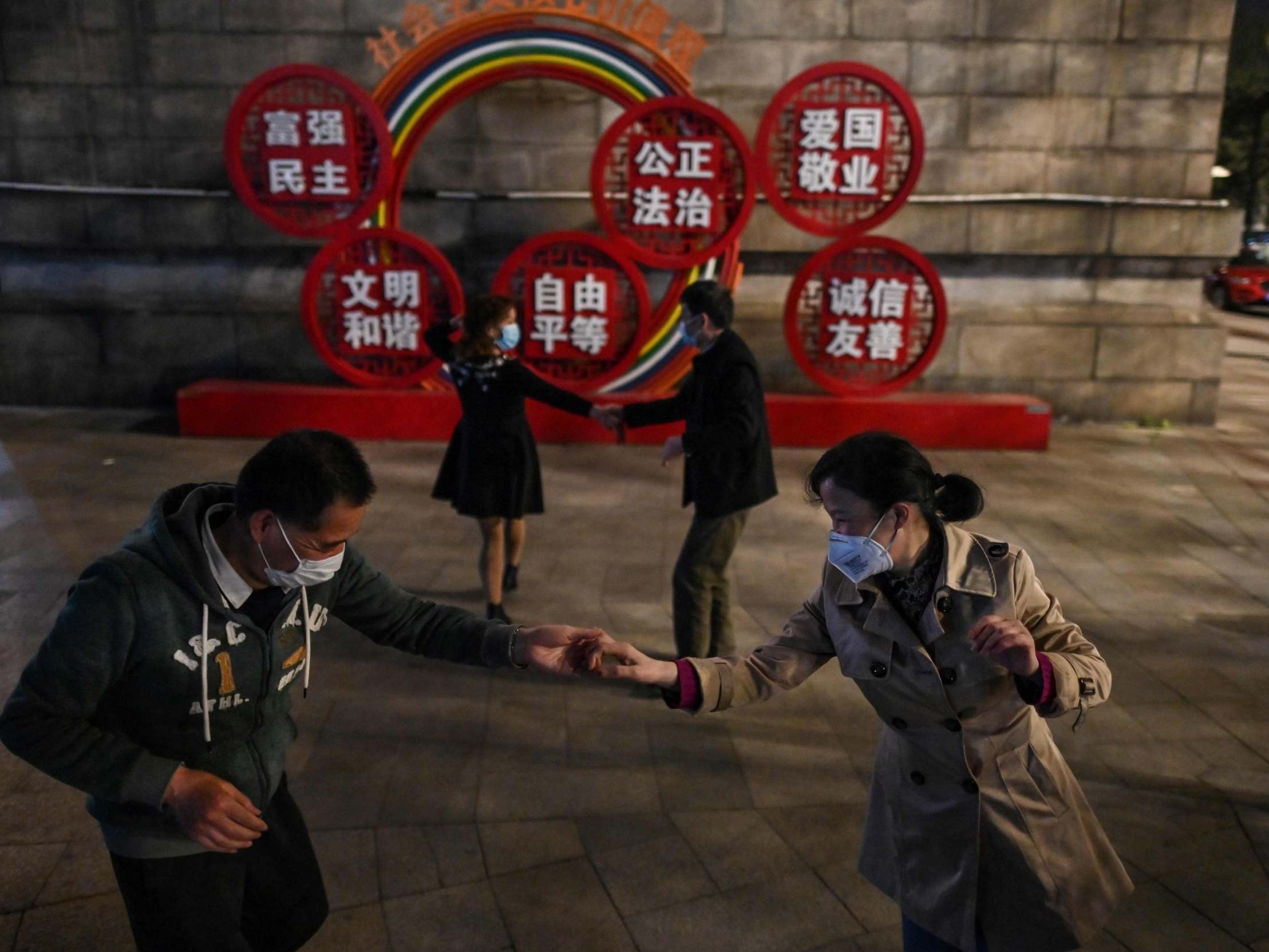 Couples are seen dancing in Wuhan as China continues to lift its strict lockdown lid (AFP)