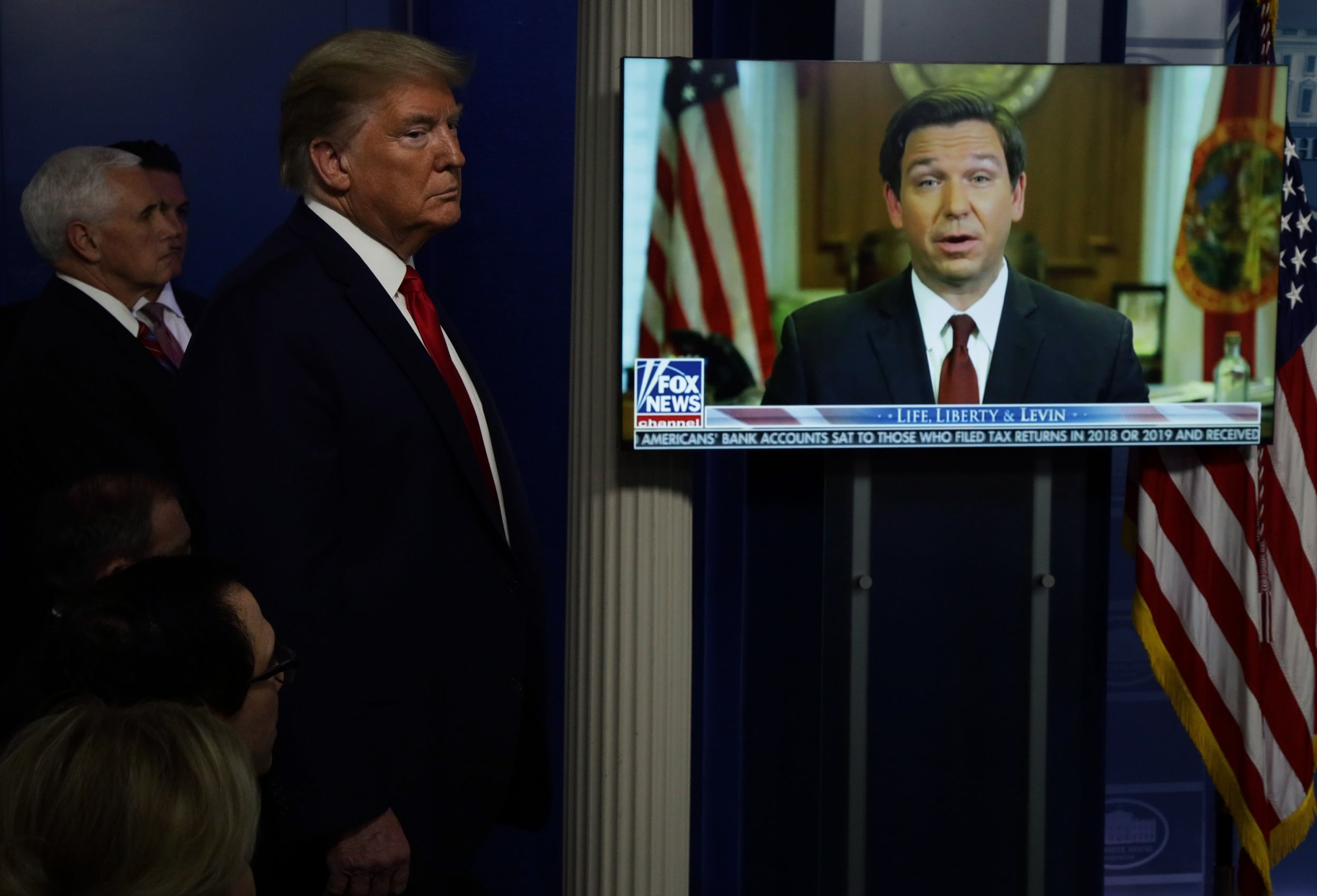 Donald Trump screens a video of people praising his handling of the coronavirus pandemic at a White House briefing