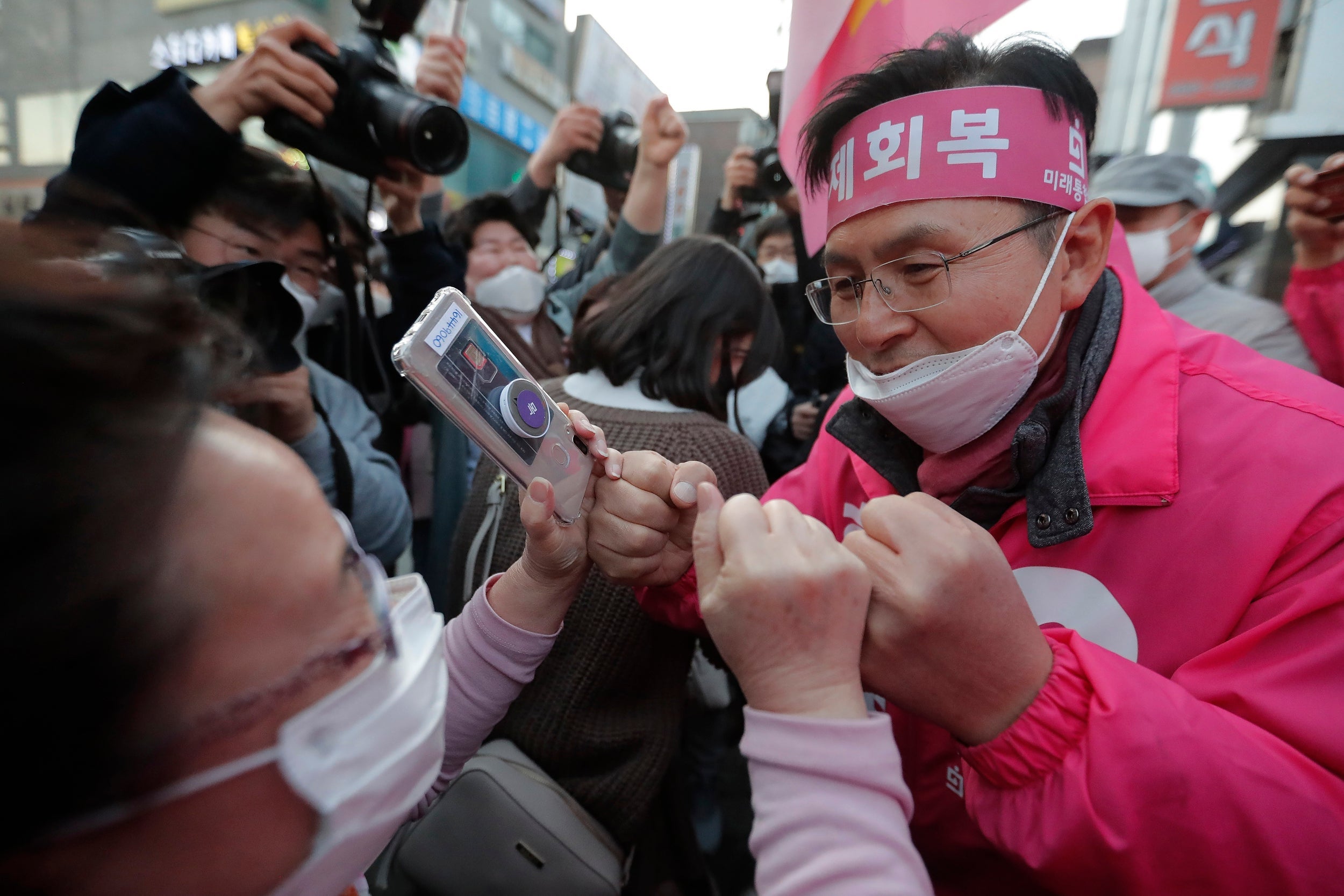 The main opposition United Future Party's candidate Hwang Kyo-ahn, right, is greeted by a supporter during campaigning on Tuesday