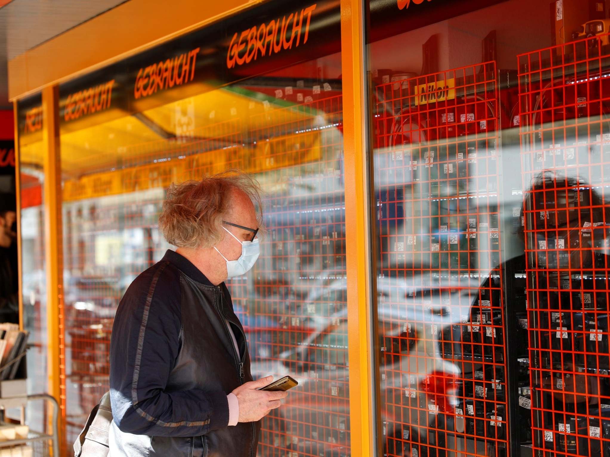 A man looks at cameras at a photo store after the Austrian government loosened its lockdown restrictions (Reuters)