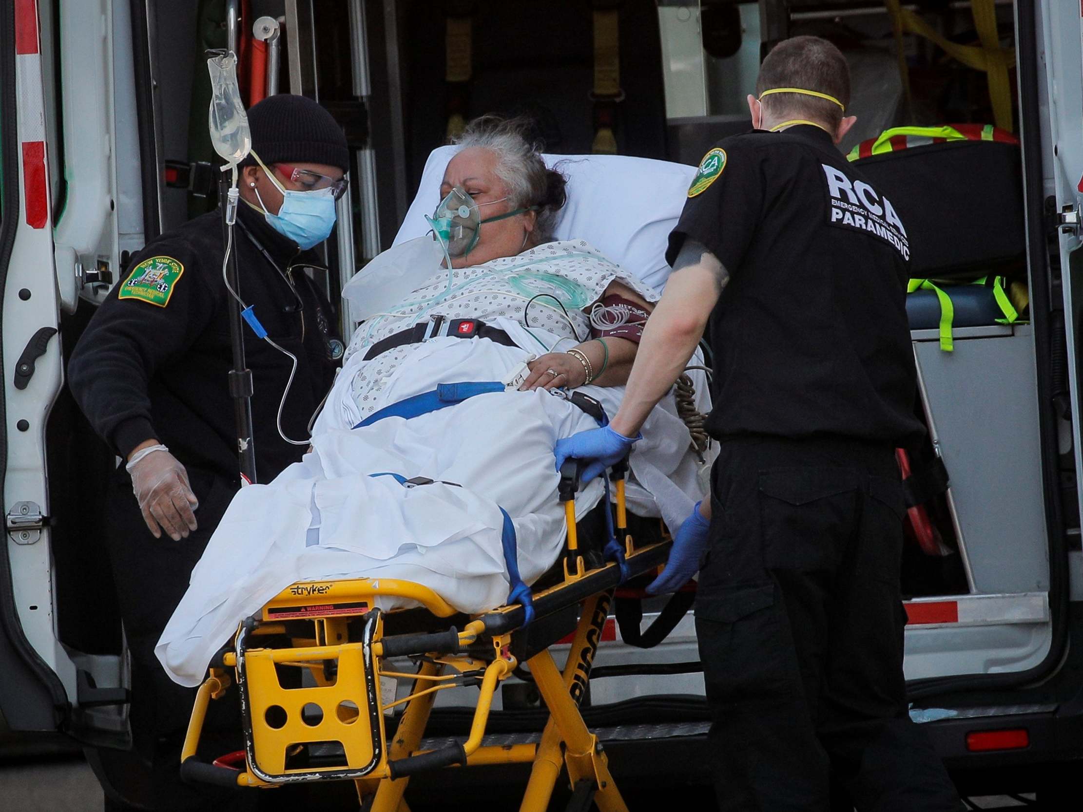 A woman is loaded into an ambulance by paramedics Chateau at Brooklyn Rehabilitation & Nursing Centre during the outbreak of coronavirus in the Brooklyn borough of New York, US, 14 April 2020.