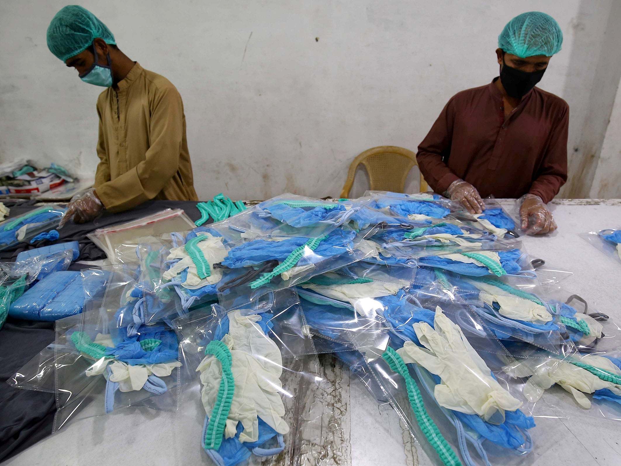 Workers pack protective masks and gloves at a garments factory amid the ongoing coronavirus pandemic in Karachi, Pakistan, on 1 April 2020.