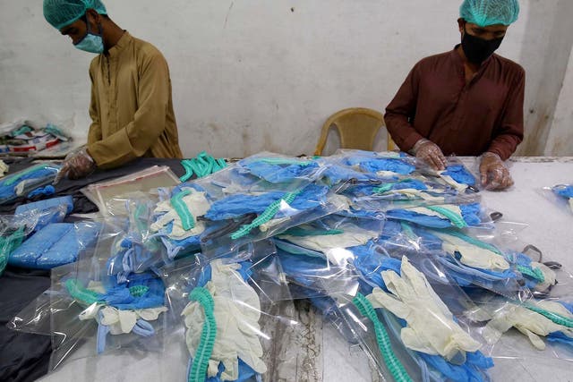Workers pack protective masks and gloves at a garments factory amid the ongoing coronavirus pandemic in Karachi, Pakistan, on 1 April 2020.