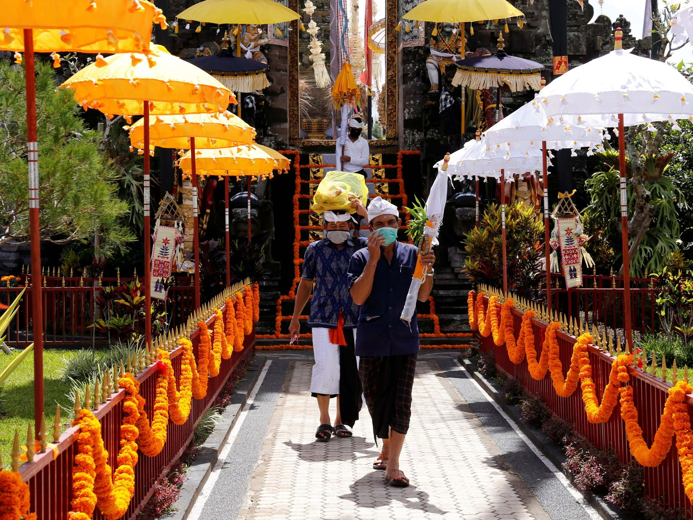 Balinese Hindus wearing face masks as they attend a ritual amid the coronavirus outbreak
