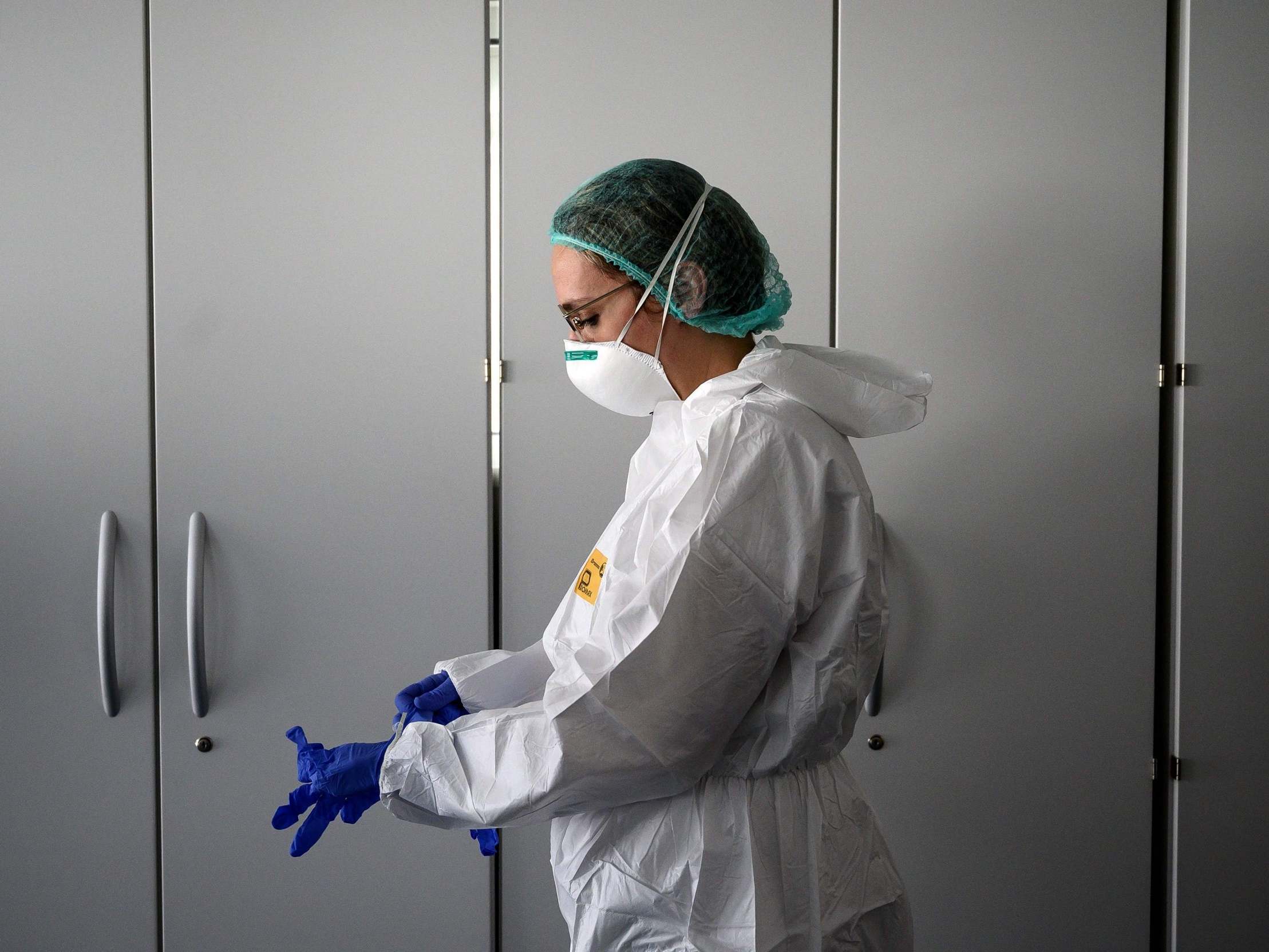 A nurse puts on protective equipment in a new hospital near Alba