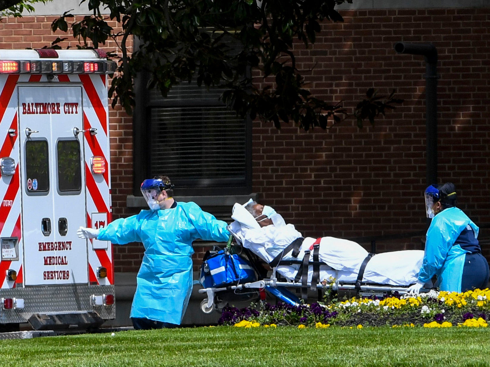 Baltimore City Firefighters load a patient they picked up from The FutureCare-Lochearn facility in Northwest Baltimore, Maryland where over 100 residents have Covid-19