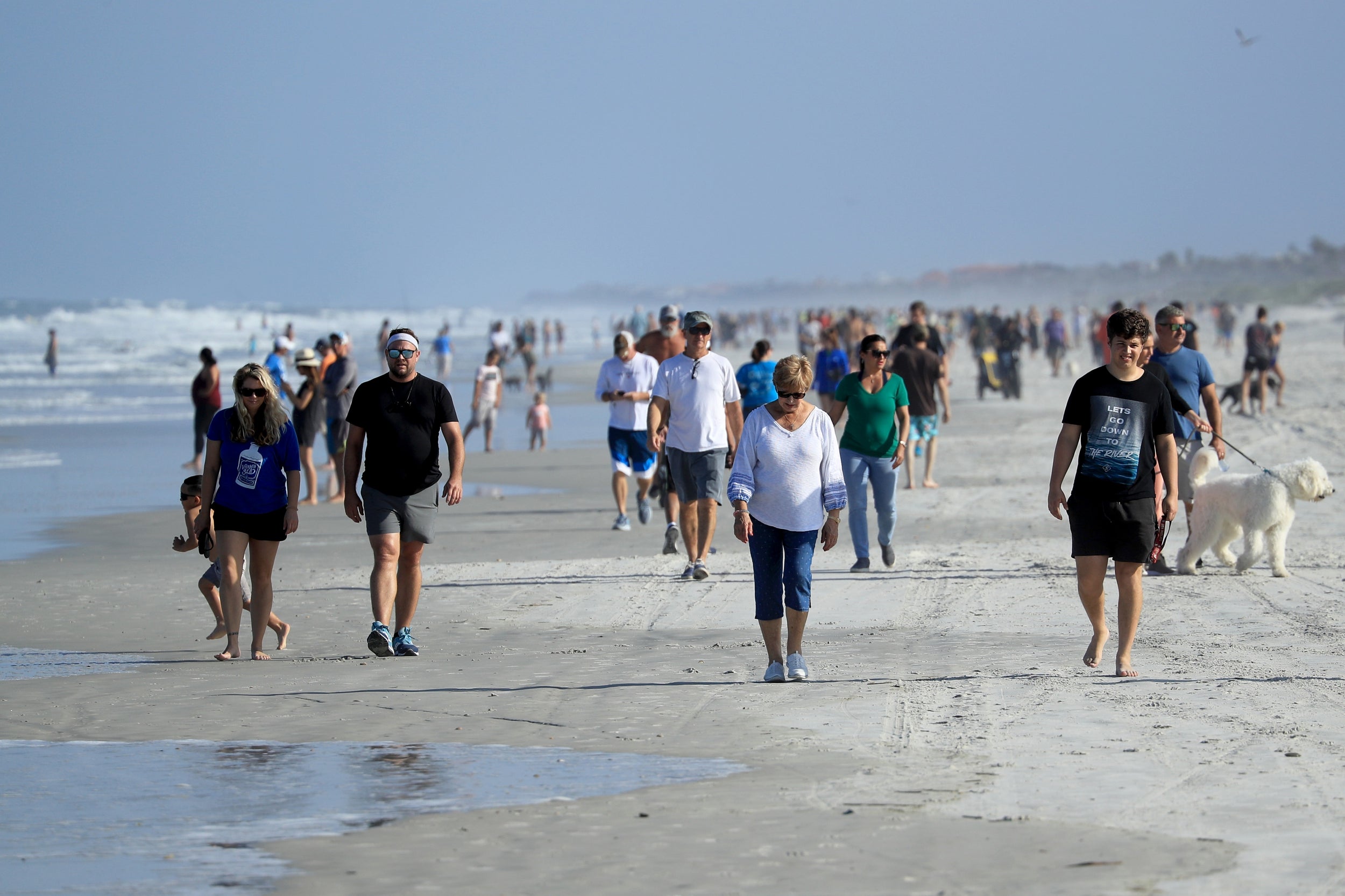 People are seen at the beach on April 17, 2020 in Jacksonville Beach, Florida. Jacksonville Mayor Lenny Curry announced Thursday that Duval County’s beaches would open at 5 p.m. but only for restricted hours and can only be used for swimming, running, surfing, walking, biking, fishing, and taking care of pets.