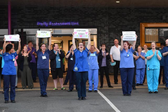 NHS staff hold up signs to thank British veteran Captain Tom Moore who raised over 13 million GBP for the NHS as they take part in a national "clap for carers" in Liverpool on 16 April 2020