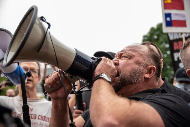 Infowars founder Alex Jones speaks into a bullhorn at a rally in Texas to call for the country to be opened up despite the risk of the COVID-19.