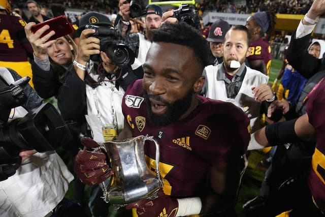 Running back Eno Benjamin celebrates with the Territorial Cup