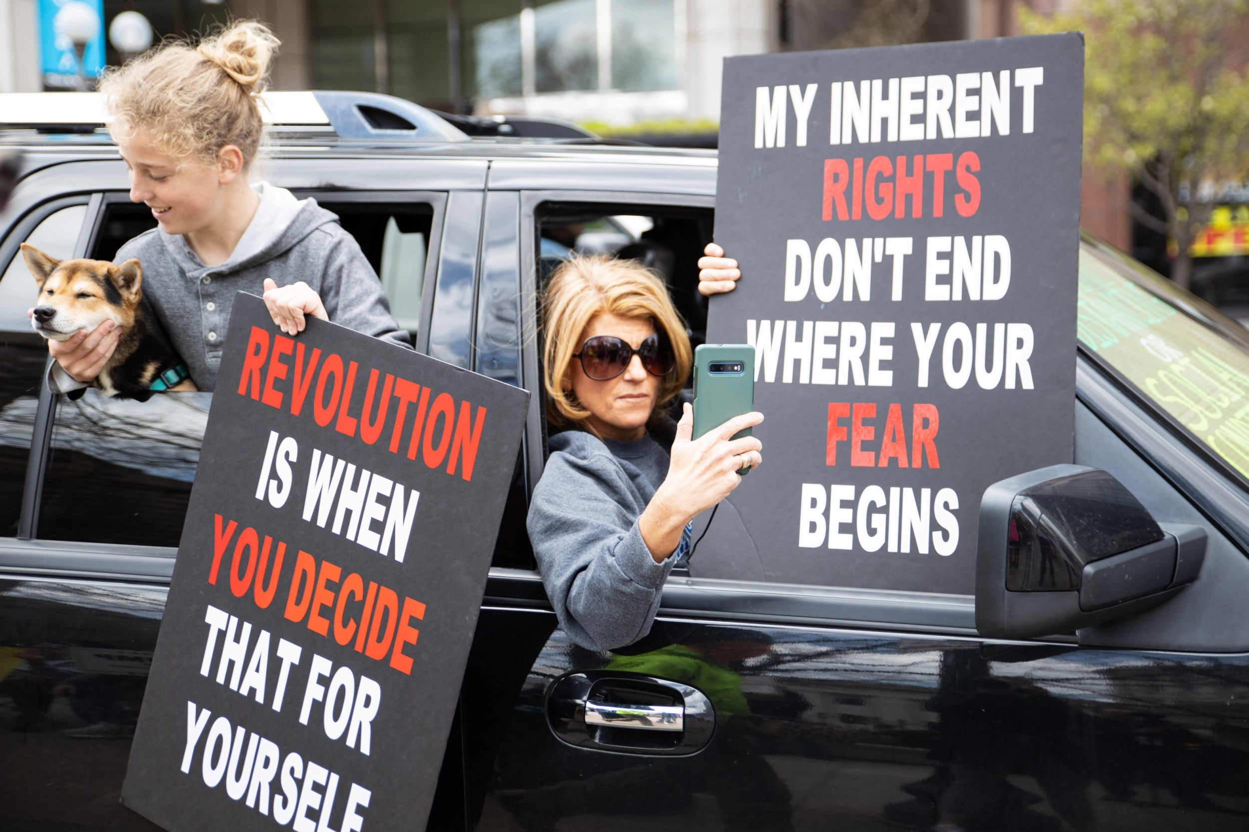 Protesters drive by the Ohio State House in Columbus, Ohio