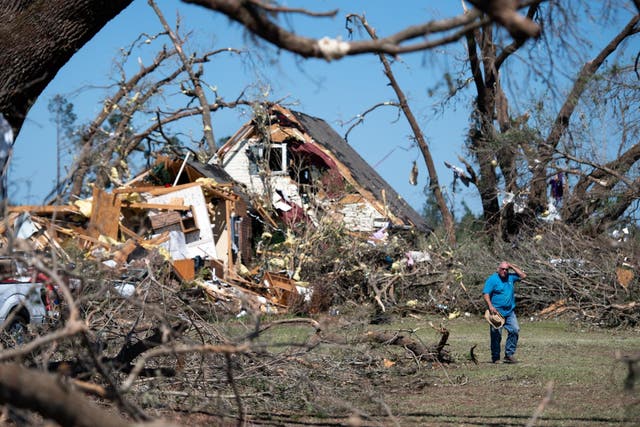 A man walks in front of a home destroyed by a tornado on 13 April, 2020 near Nixville, South Carolina, USA