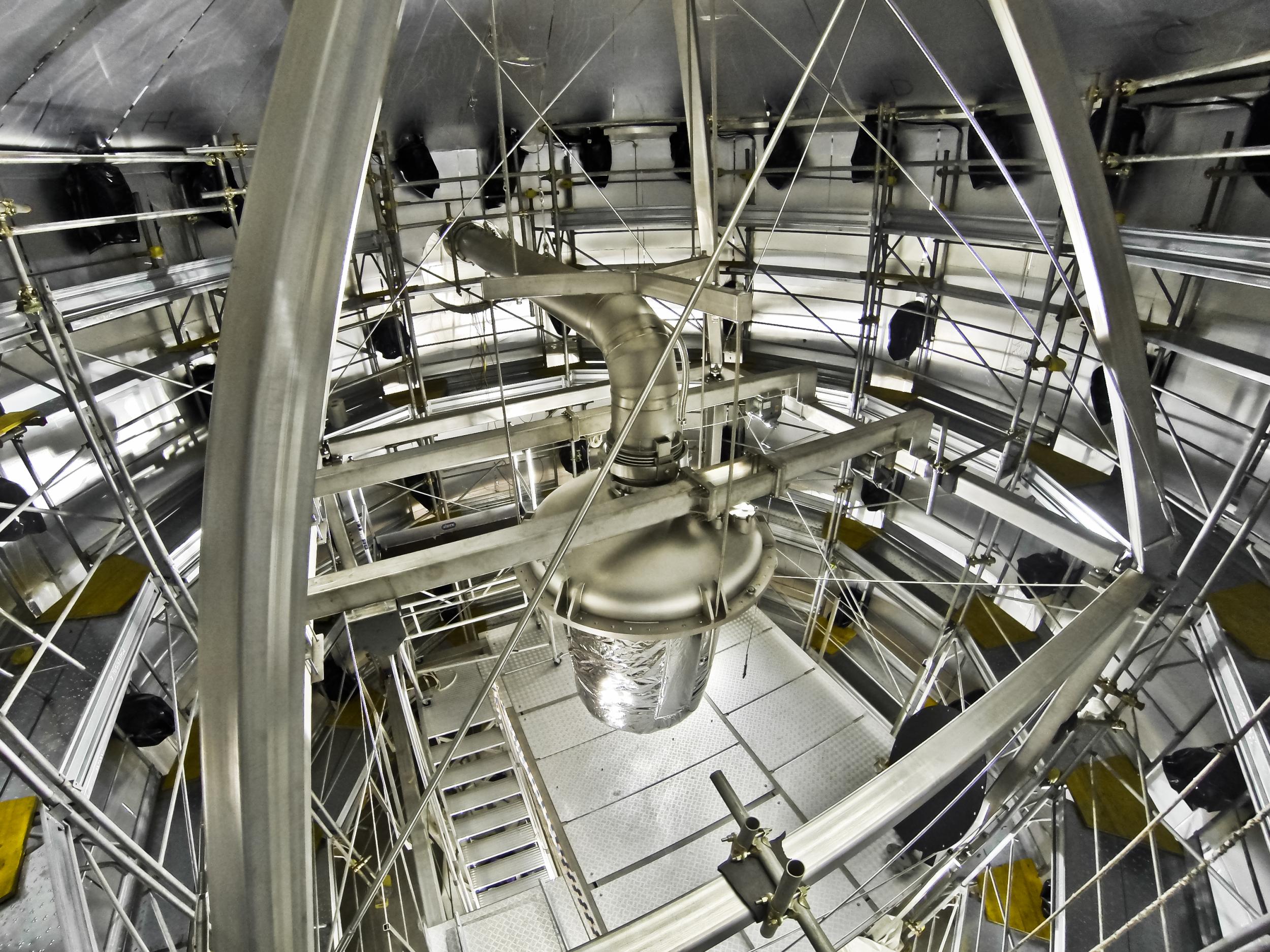 A cryostat hangs over a water tank