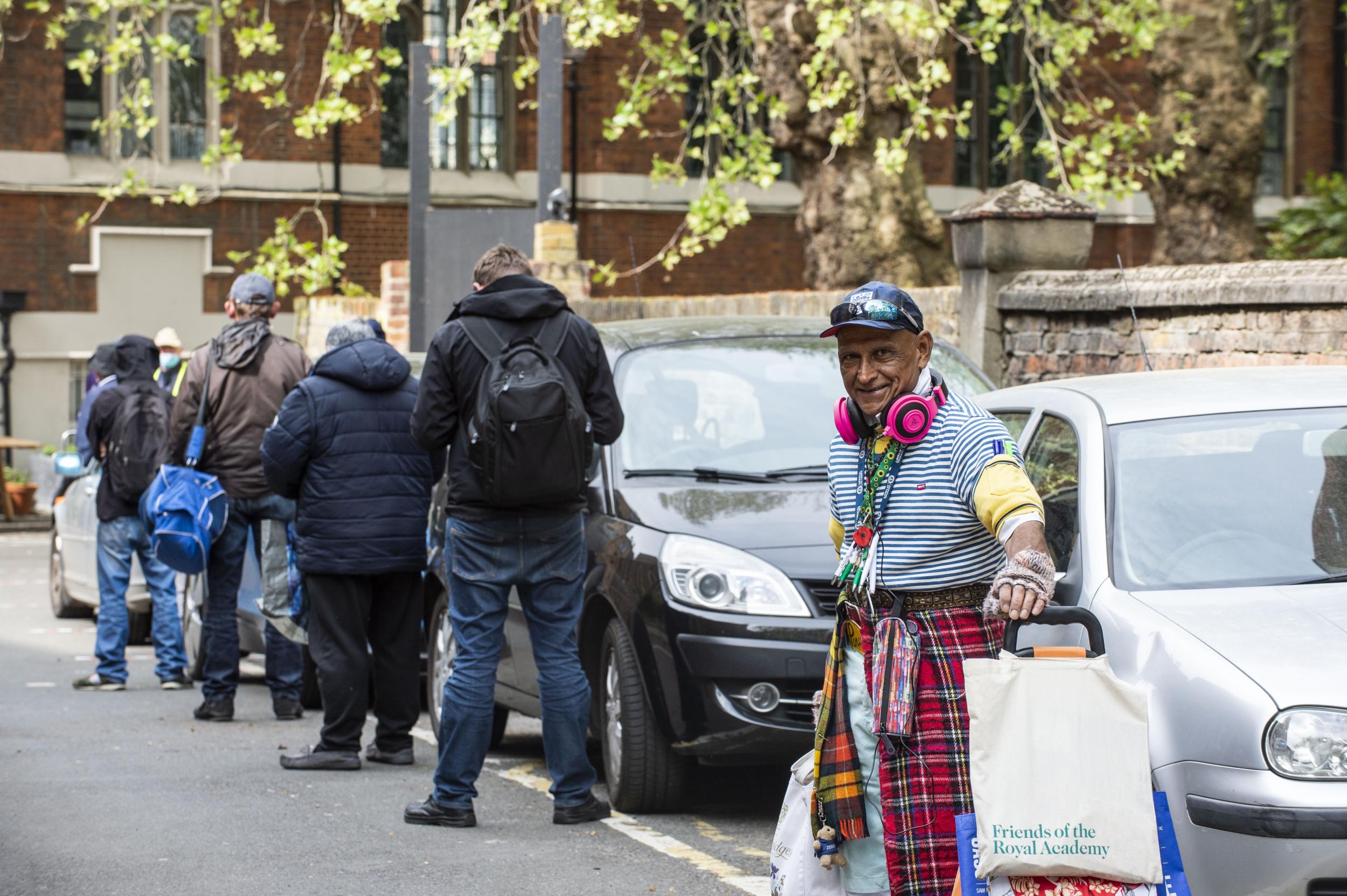Homeless and vulnerable people queue for food outside the St. Cuthbert's Centre. They are spaced 2 metres apart to help stop the spread of Covid 19. The 30-year-old charity was joined by Refettorio Felix in 2017 through a collaboration with Chef Massimo Bottura's non-profit organisation Food for Soul, creating the current Refettorio Felix at St. Cuthbert's Centre. The centre helps sustain and support vulnerable people.