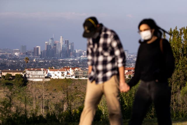 A couple wear face masks on a hike above downtown Los Angeles.