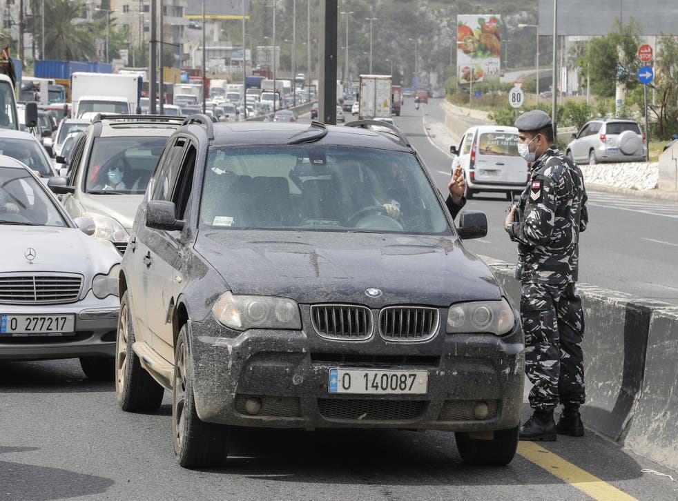 Lebanese security forces stop vehicles at a highway checkpoint near Beirut as part of coronavirus lockdown measures