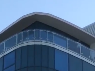 Footage taken near the Dockside Shopping Outlet of a man on a balcony