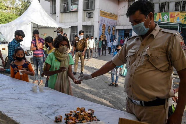 Migrant labourers get tea and refreshment at a camp set up by Delhi Government, after the fear of lockdown-induced hunger sparked an exodus of hundreds of thousands of people