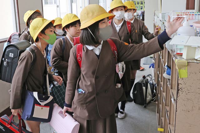 Children disinfect their hands before leaving school in Osaka