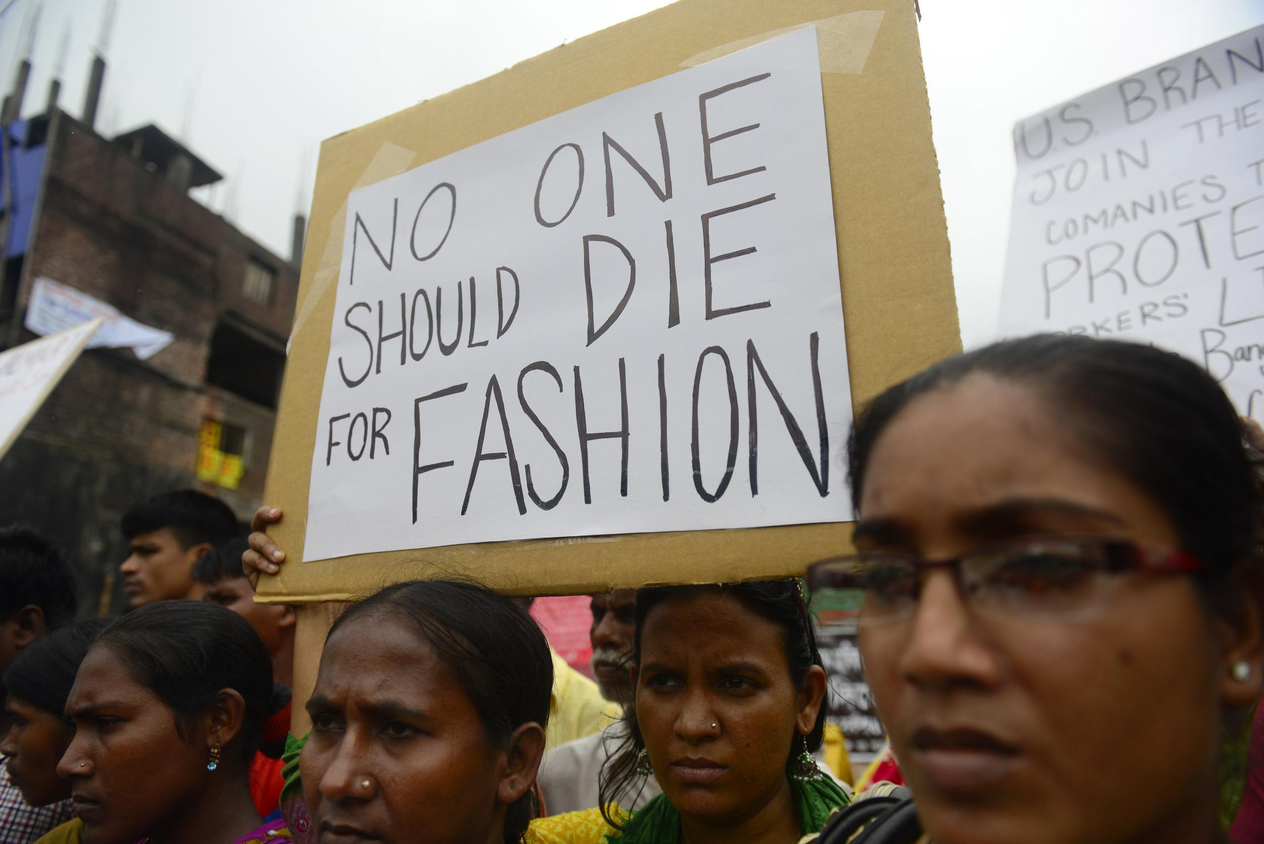 Relatives of Bangladeshi workers who lost their lives gathered with banners and placards at the site (Getty)