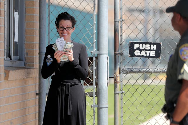 Shaye Spell, wife of pastor Tony Spell, flashes wads of cash as she waits outside the East Baton Rouge parish jail. Tony Spell was arrested for flouting lockdown orders during the coronavirus pandemic