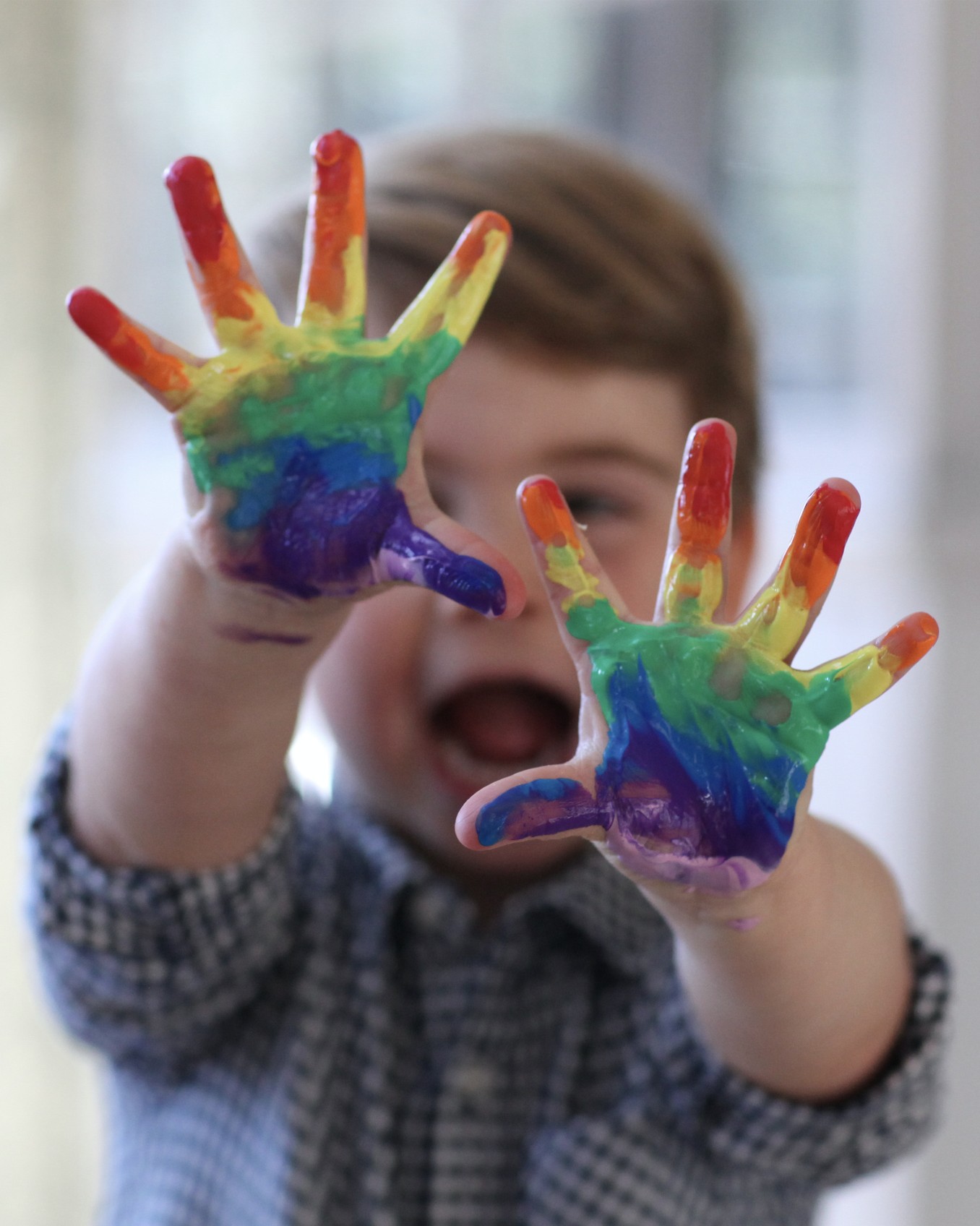 Kate captured her son as he grins at the camera while holding up his painted palms and fingers (AP)