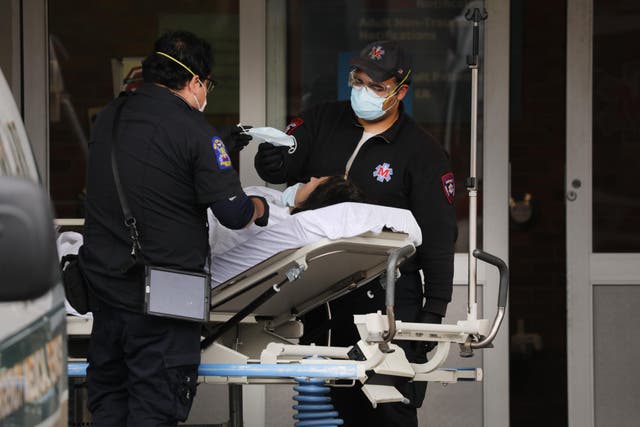 Medical workers transport a patient outside of a special coronavirus intake area at Maimonides Medical Center in Brooklyn