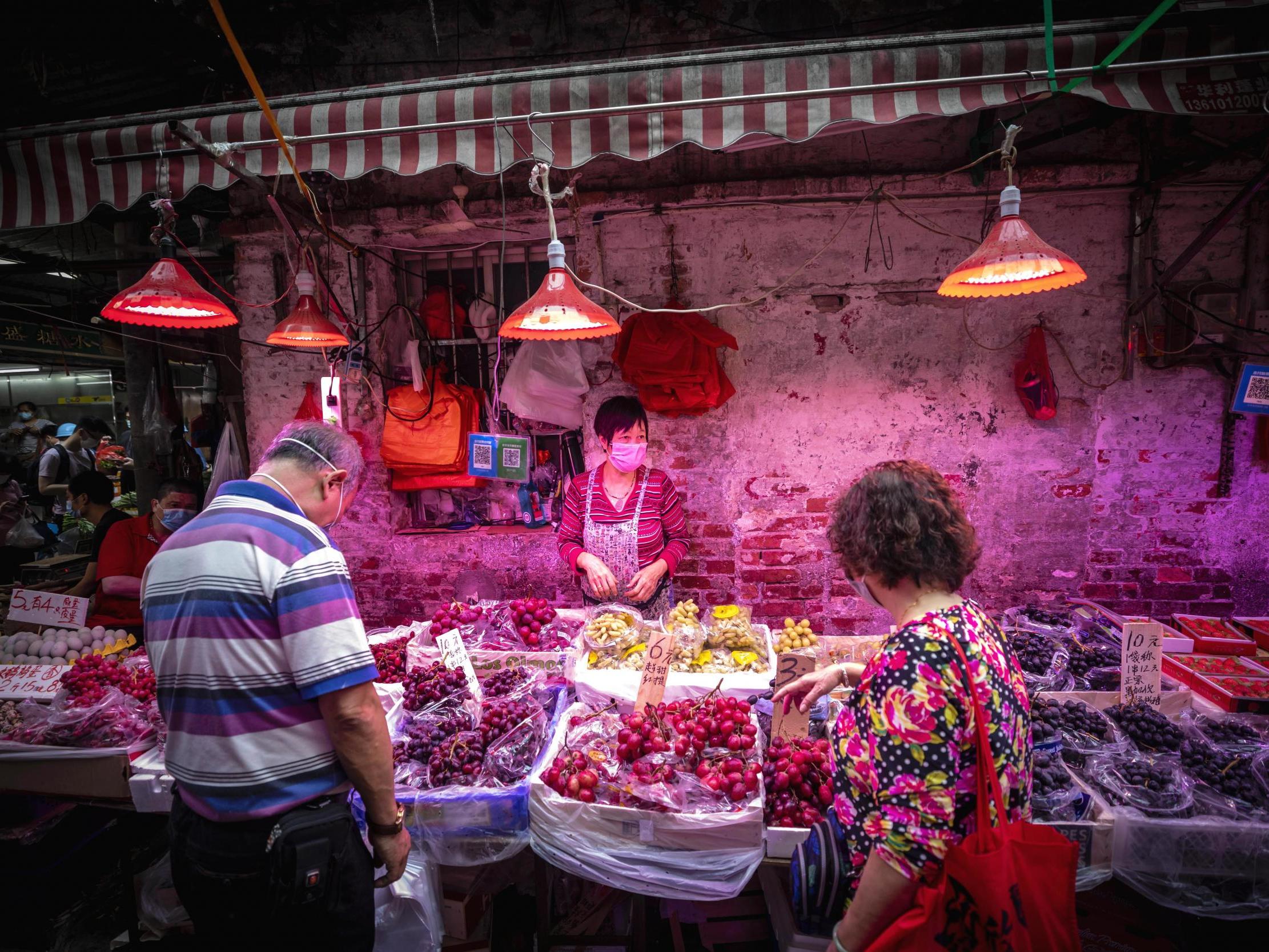 People buy food at a wet market in Guangzhou, China