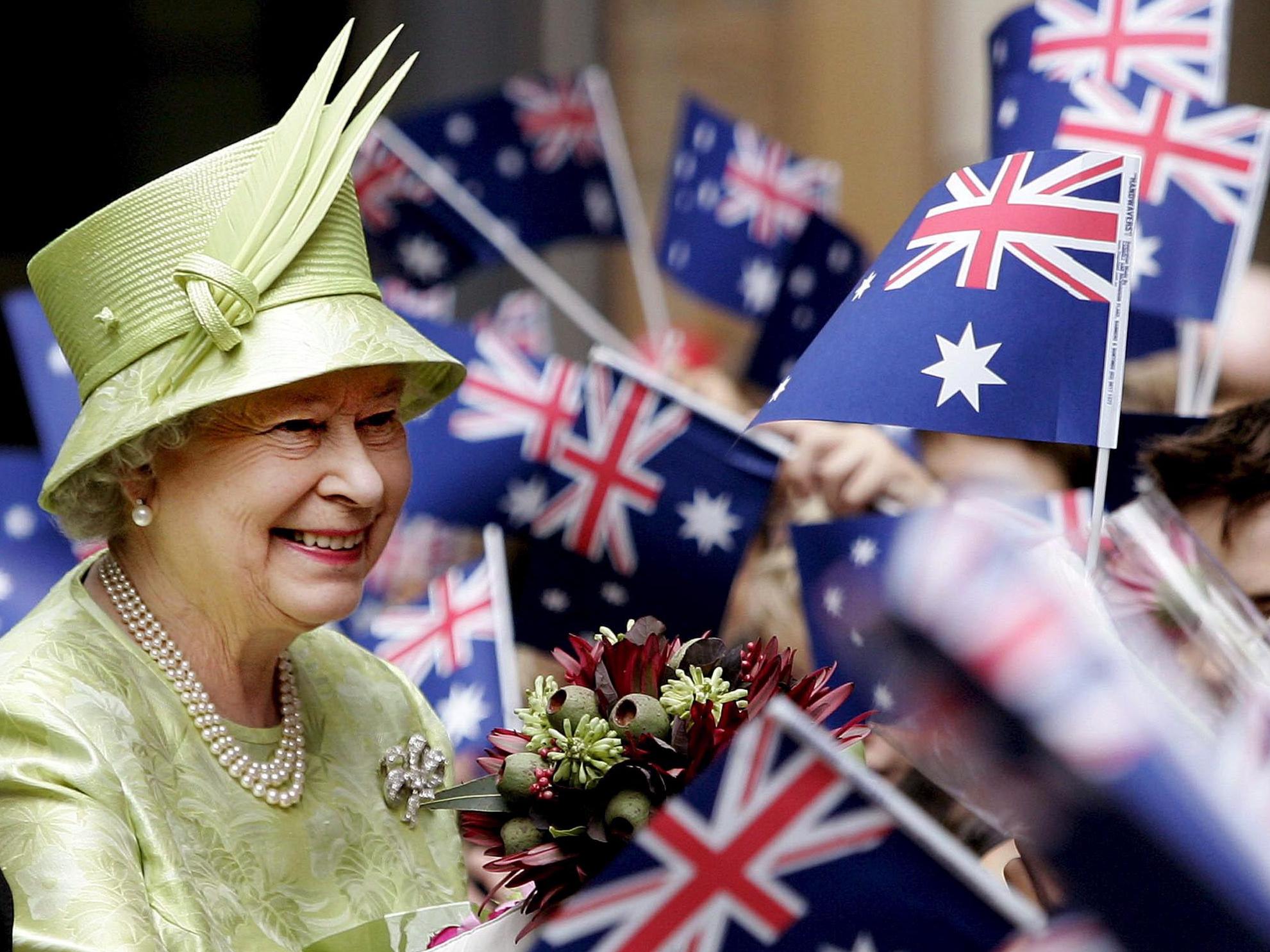 The Queen receives flowers from schoolchildren waving Australian flags after the Commonwealth Day service in Sydney, 2006