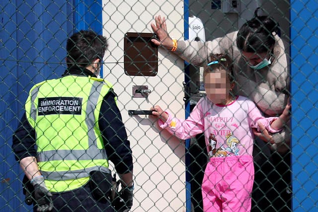 An Immigration Enforcement officer helps to process a mother and young daughter after they were brought into Dover, Kent, along with a group of people thought to be migrants following a number of small boat incidents in The Channel earlier on Friday