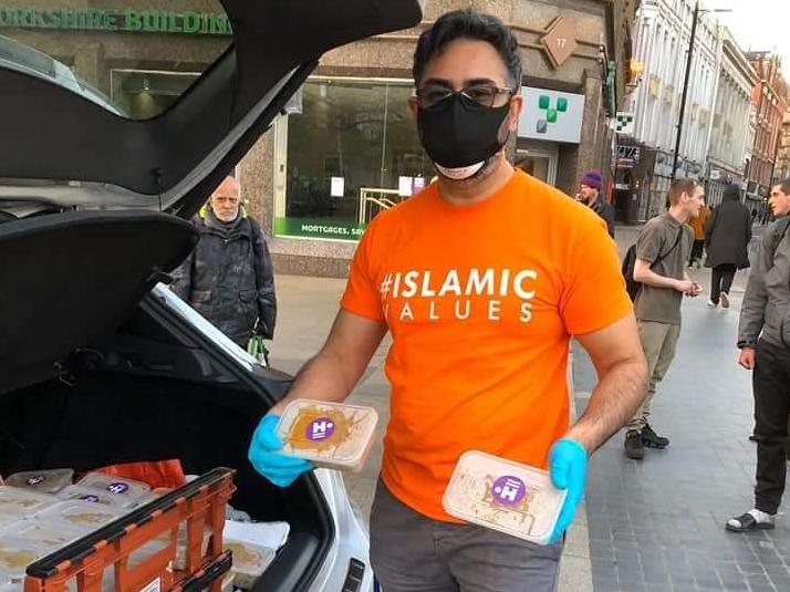 A volunteer with the The Myriad Foundation feeds homeless people in central Manchester during the coronavirus crisis