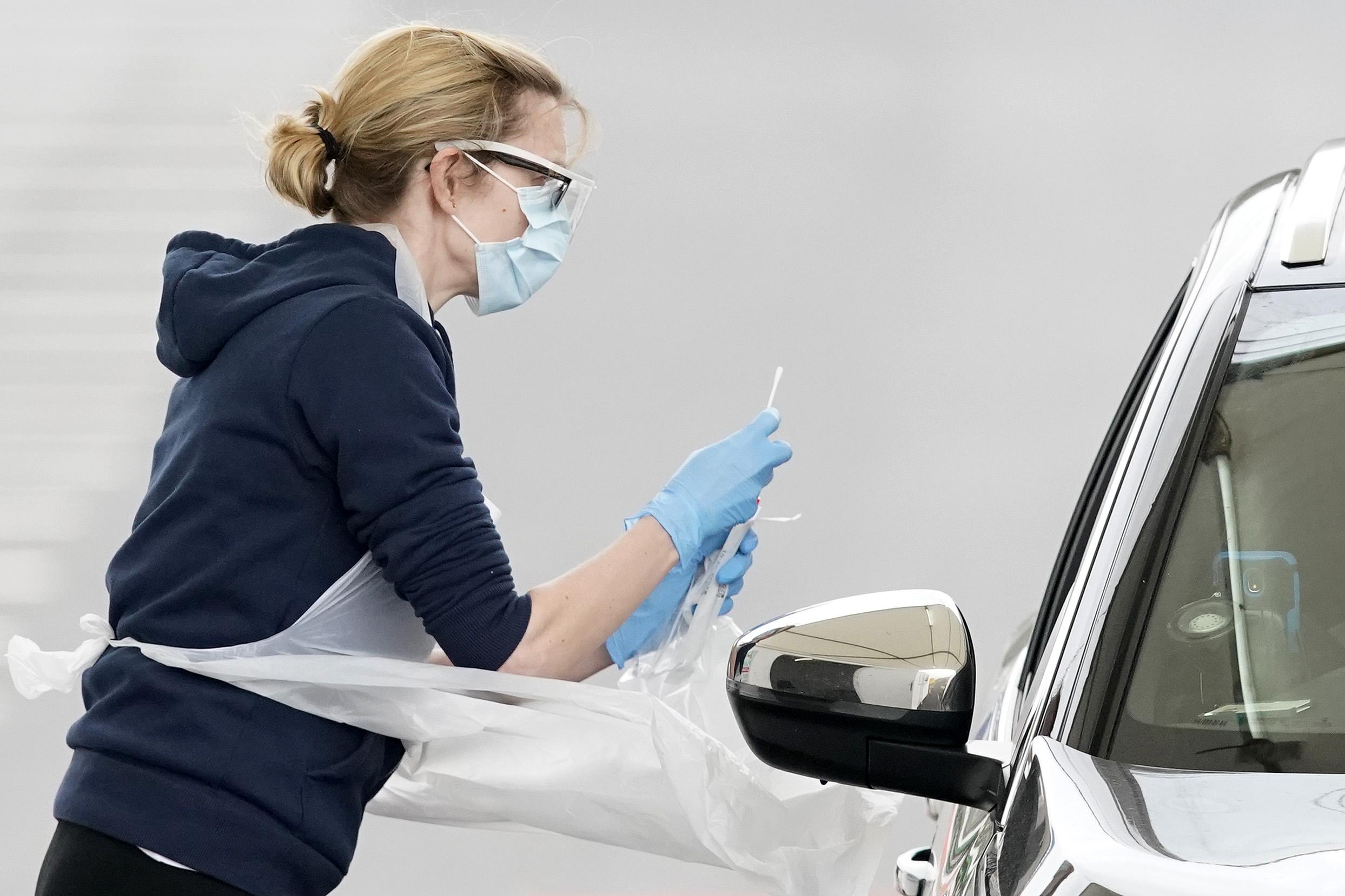 A nurse takes a swab at a Covid-19 drive-through testing station at Manchester airport on 4 April 2020