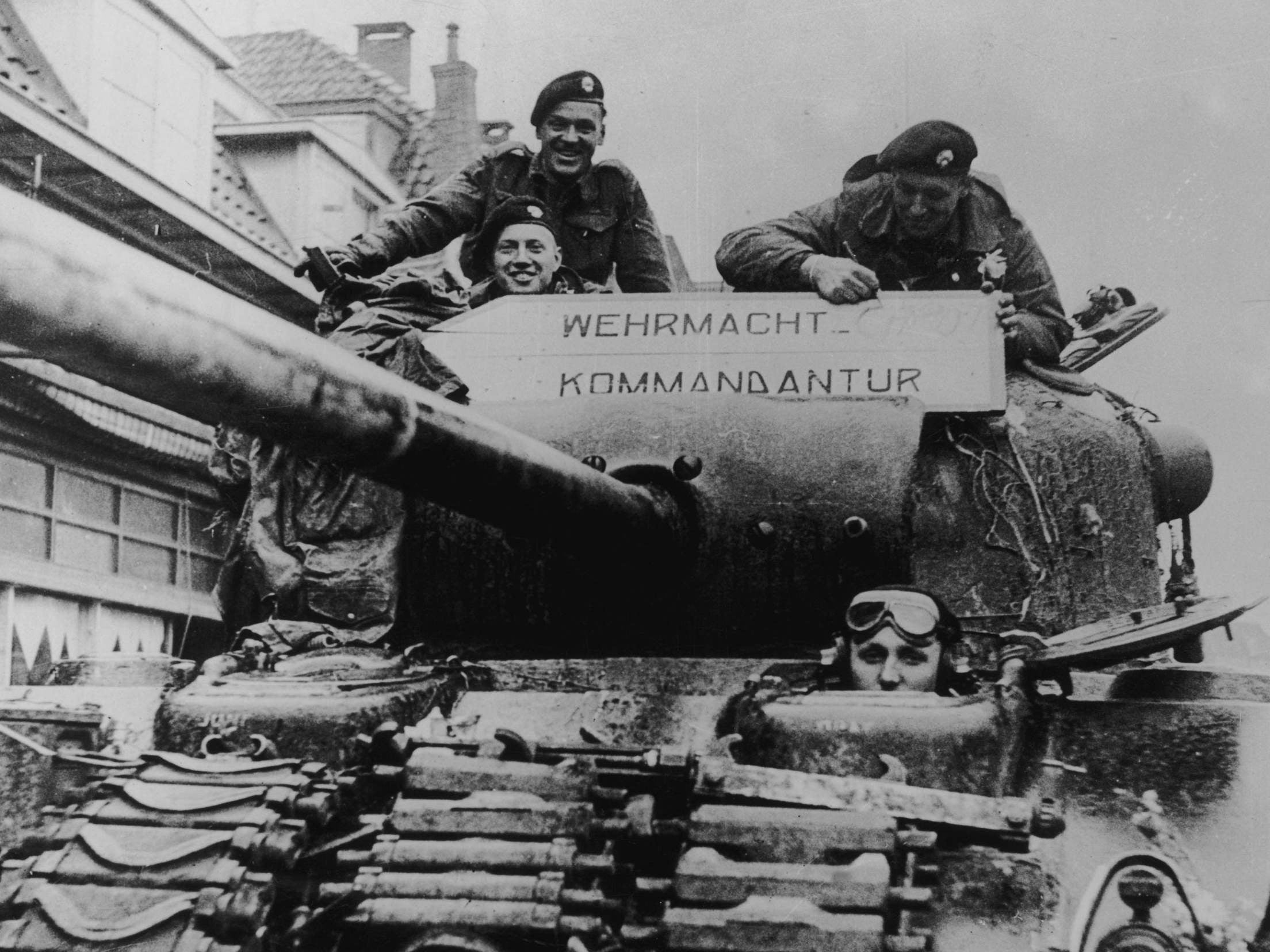 Canadian soldiers add ‘Caput’ to the Wehrmacht Headquarters sign on a tank after liberating the Dutch town of Almelo