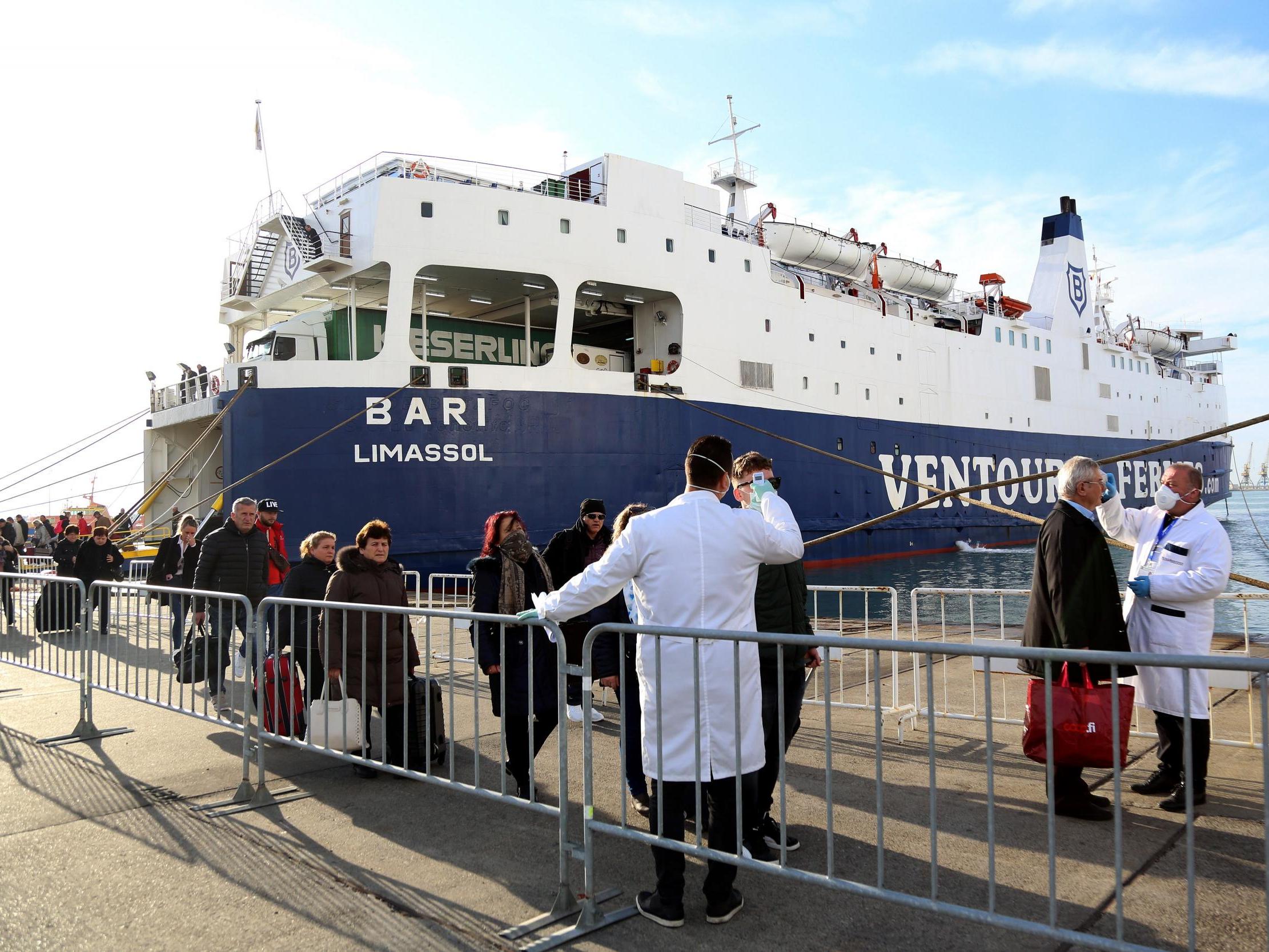 Medical staff check incoming passengers coming from Italy for virus symptoms in the Albanian port city of Durres