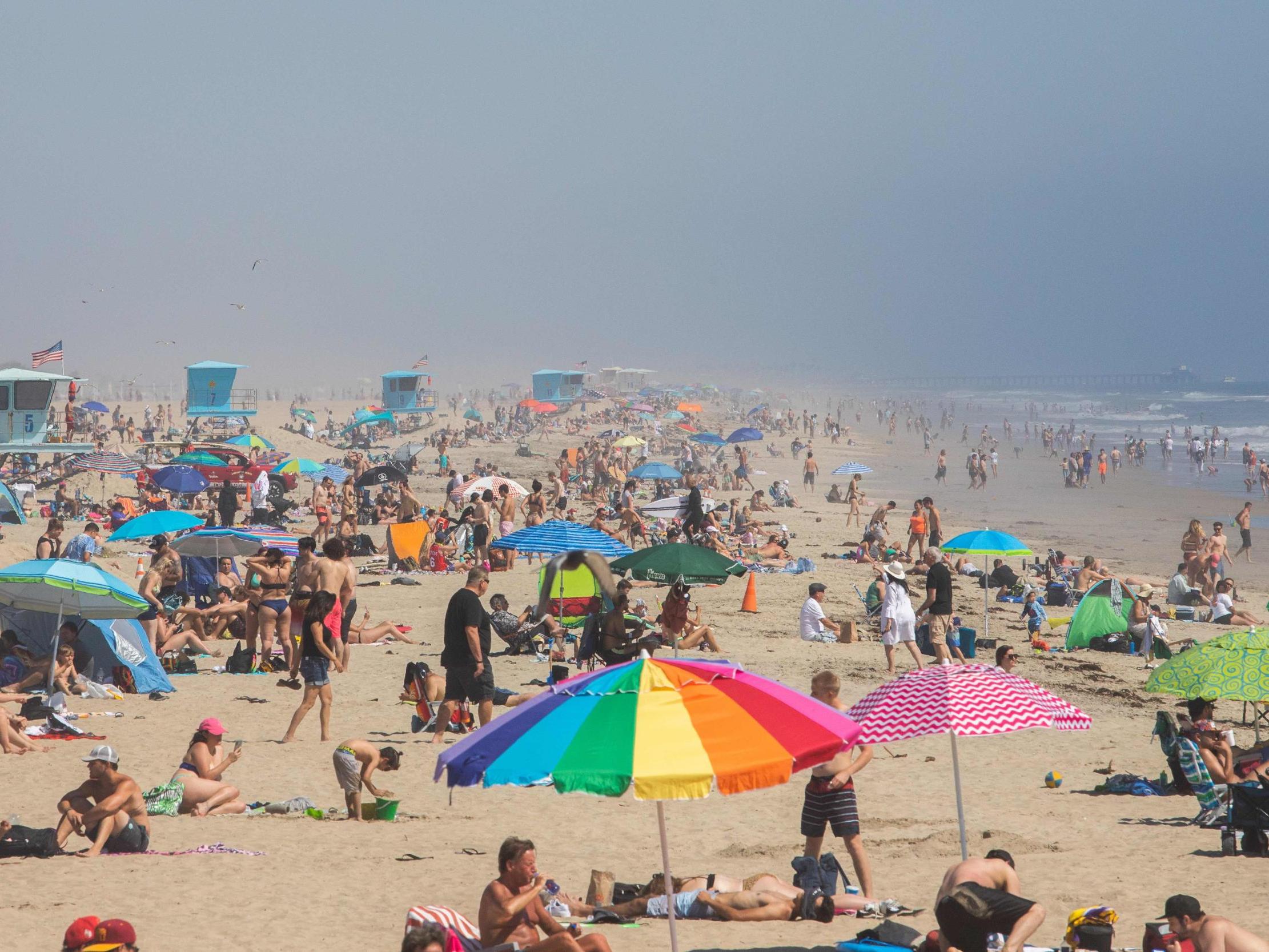 People enjoy the beach amid the novel coronavirus pandemic in Huntington Beach, California on 25 April 2020