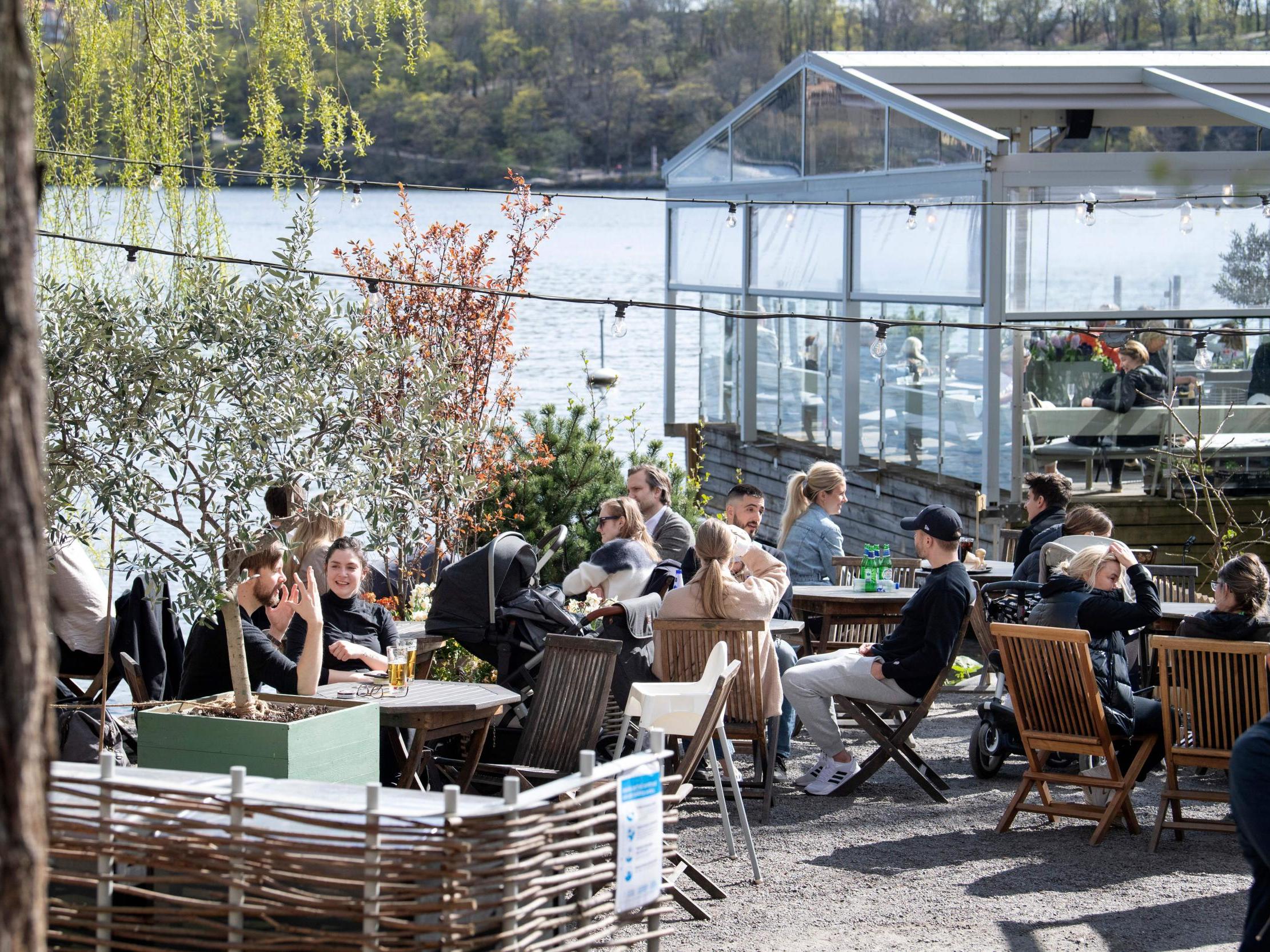 People sit in the spring sun at an outdoor restaurant in Stockholm