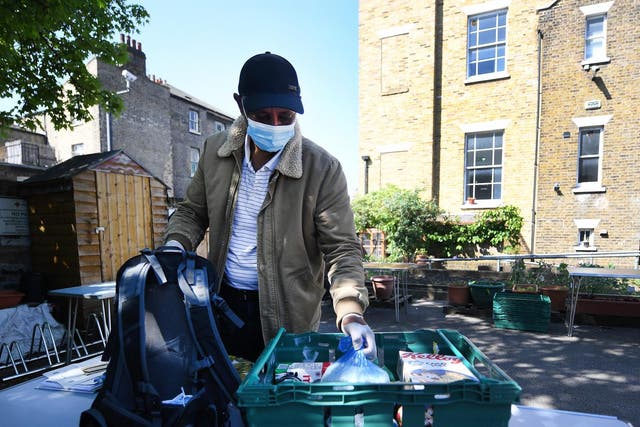An asylum seeker receives emergency food at a Red Cross centre in east London on 23 April 2020
