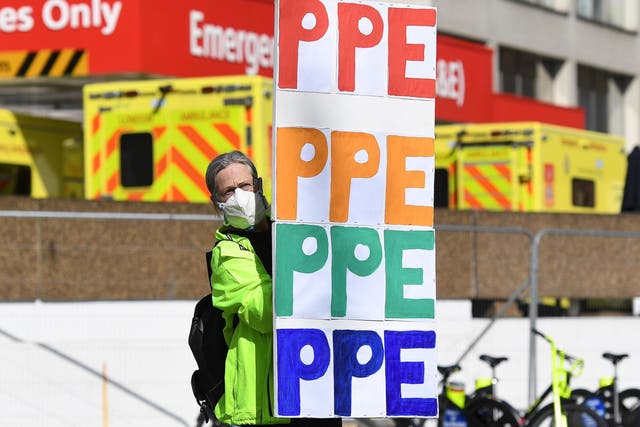 A protester outside St Thomas' hospital holds up a placard demanding access to PPE