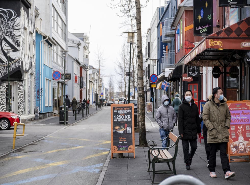 Tourists with masks walk down Laugavegur street in downtown Reykjavik