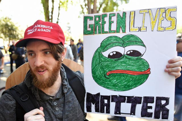 Coded: a protester holds a sign depicting Pepe the frog, during a rally in Berkeley, California