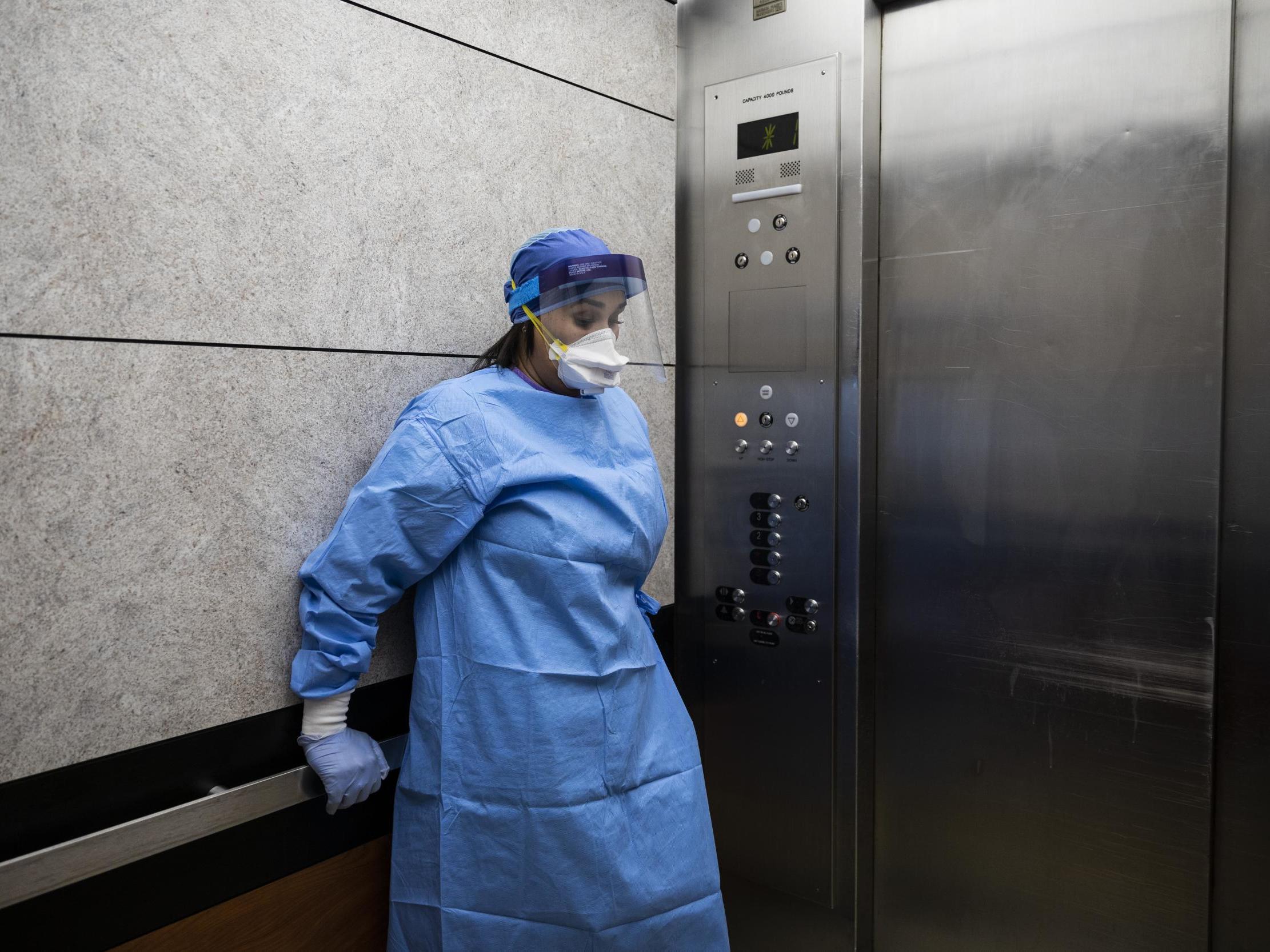 Ms Reese takes a minute to herself in an elevator after an 80-year-old man suffering from Covid-19 died at Roseland Community Hospital in Chicago