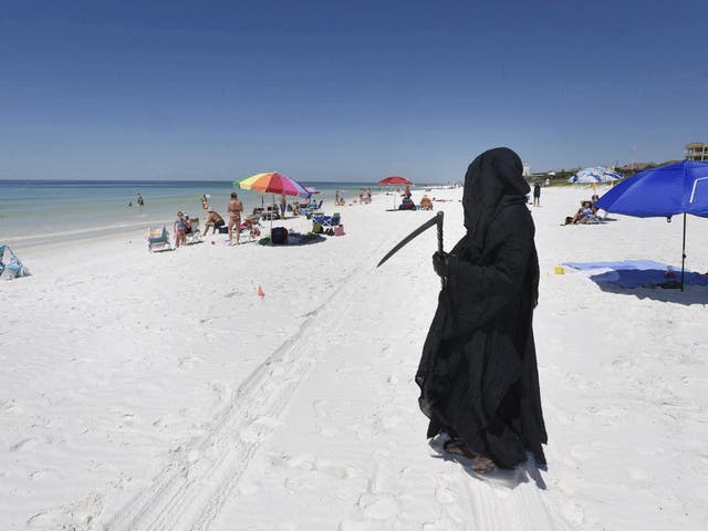 Florida Attorney Daniel Uhlfelder, dressed as the Grim Reaper, walks the newly-opened beach near Destin, Florida, on 1 May, 2020.