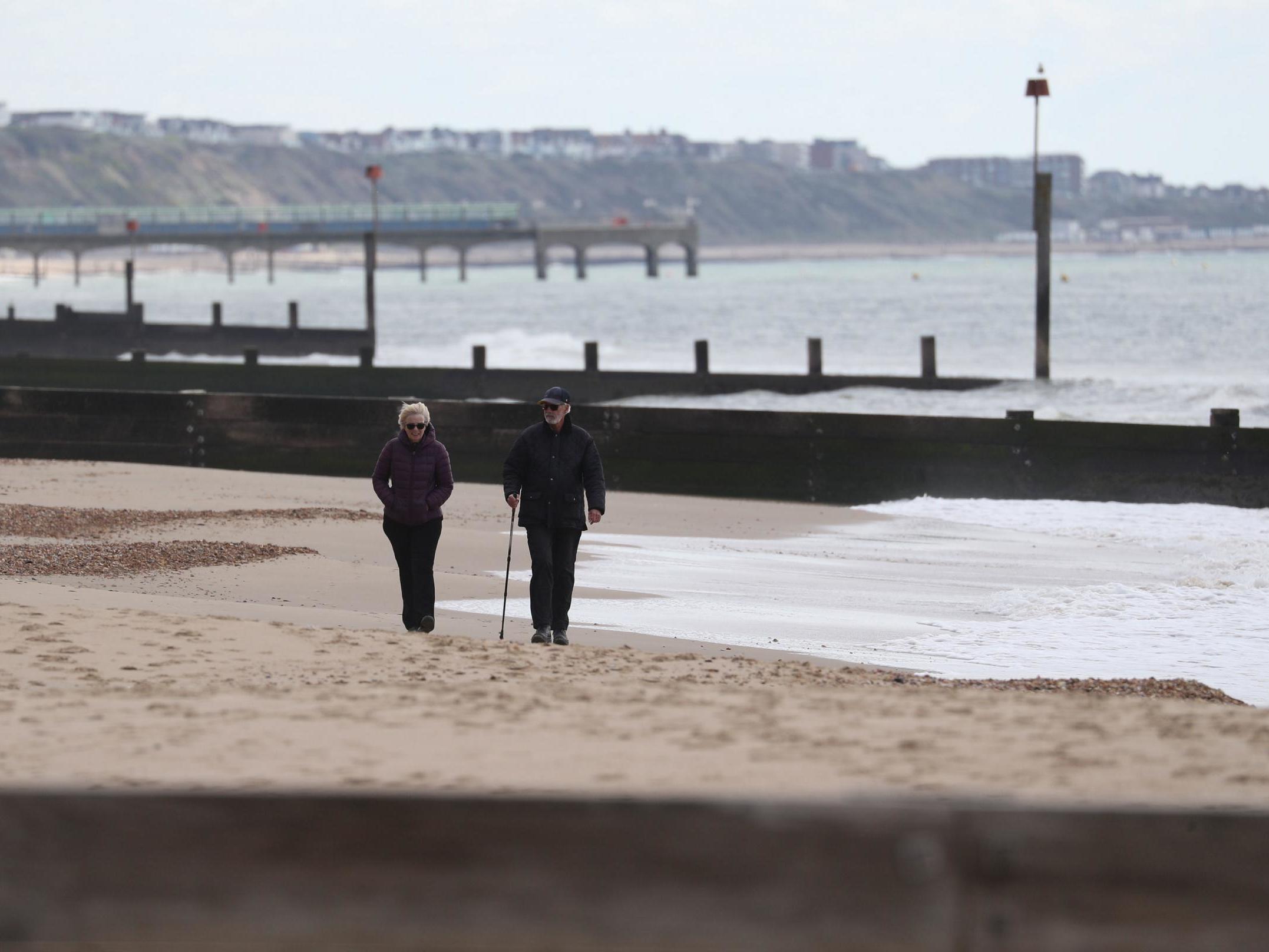 People make their way along a near deserted Bournemouth beach in Dorset as the UK heads towards a seventh week in lockdown on 2 May, 2020.