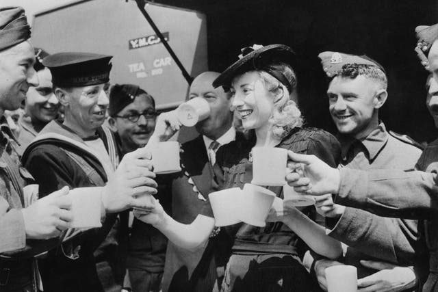 Dame Vera Lynn serves cups of tea to servicemen in 1942