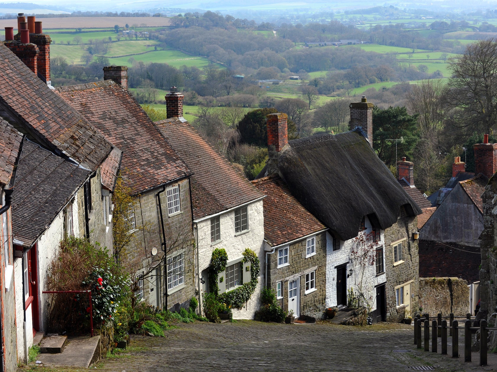 The rural idyll: a row of quaint British cottages built down a hill and set against the rolling English countryside